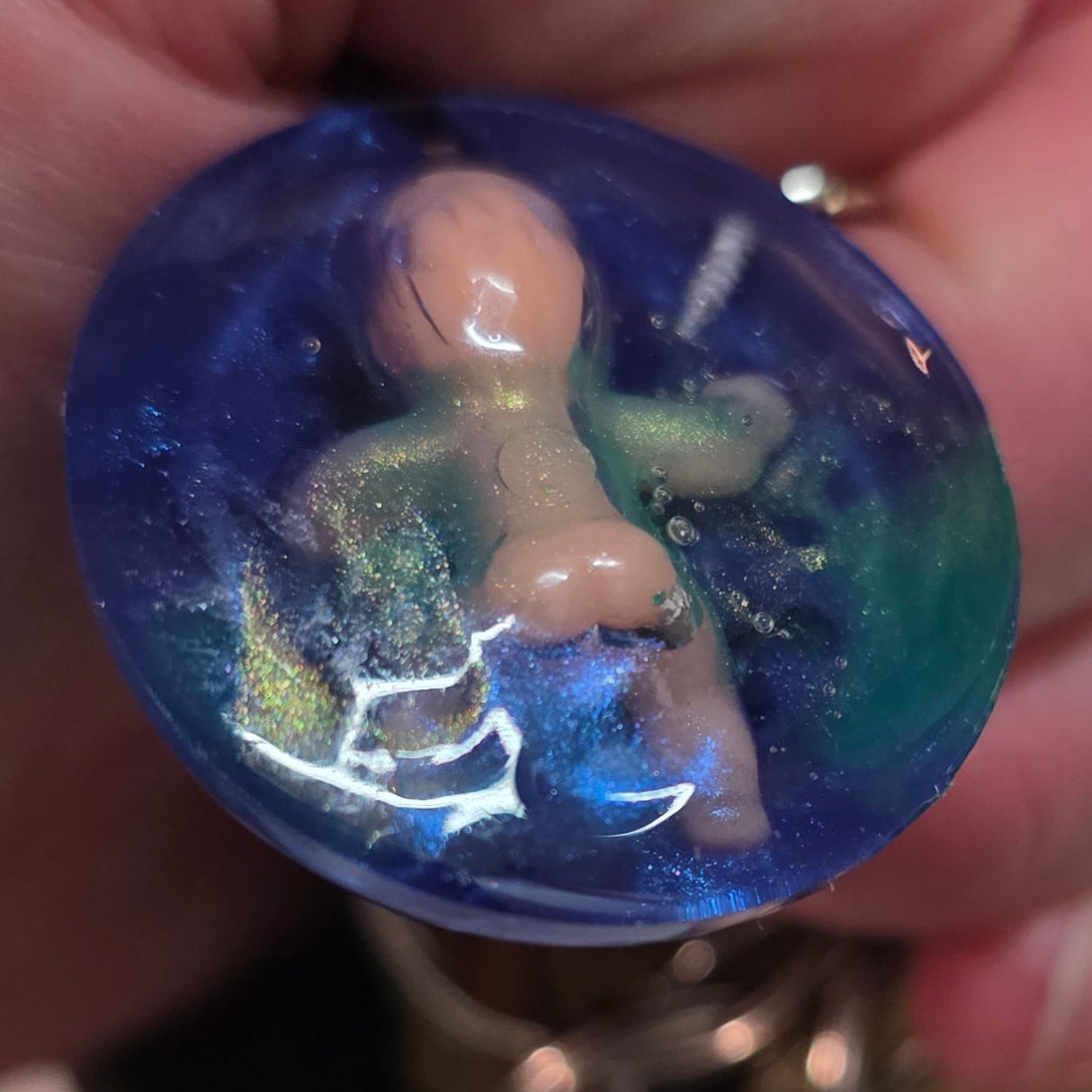 Hand holding a creepy bsby blue marbled keychain