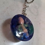 Keychain with a blue oval pendant on a light gray surface