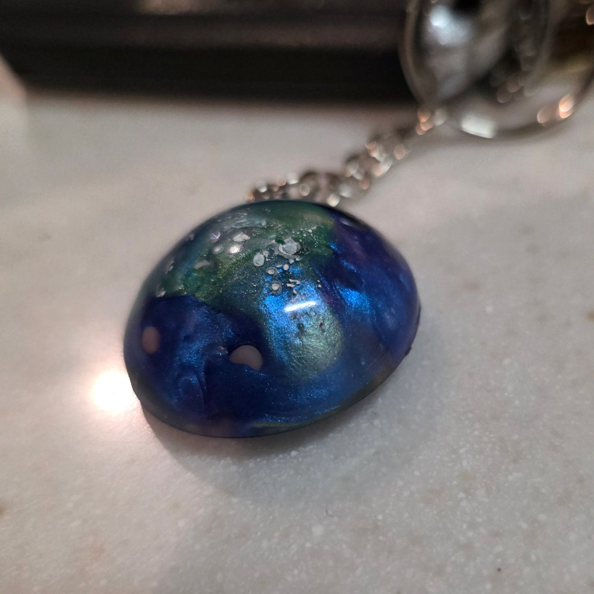Keychain with a blue marbled pendant on a light gray surface