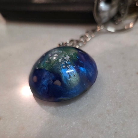 Keychain with a blue marbled pendant on a light gray surface