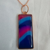 Necklace with a rectangular pendant featuring blue and pink colors on a light gray background