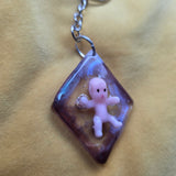 Keychain with a small figurine on a textured surface