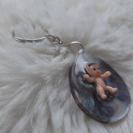 Decorative keychain with a small figurine on a textured surface