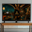 A large flat-screen television displaying a retro-futuristic sci-fi interior scene, placed on a rustic wooden table in a minimalist studio setting with a gray concrete floor and white wall.